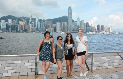 Icon students standing in front of a city skyline in Asia