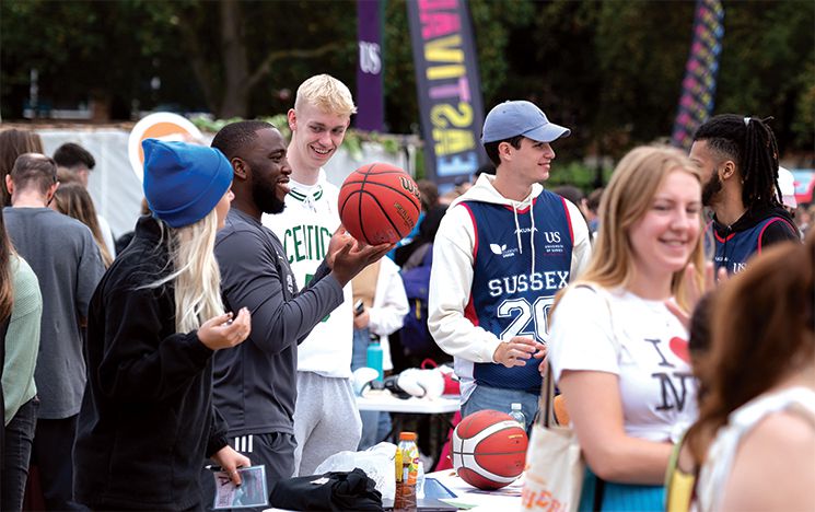 Students with basketballs at an outdoor society stall
