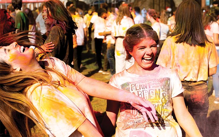 Students covered in paint enjoying the Holi festival